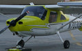 Two yellow Cessna 162 Skycatchers, N7030B nearest, parked on the Van Nuys ramp at sunset