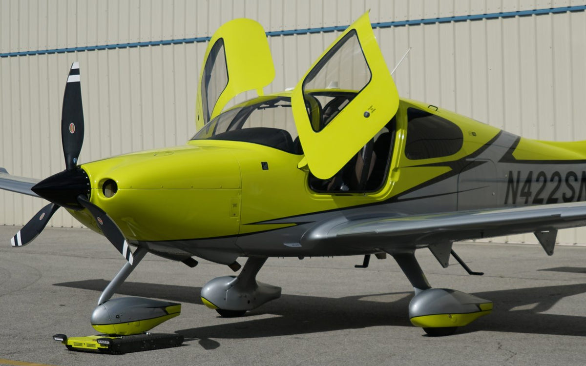 Cirrus SR22T with both doors open on the ramp outside the hangar