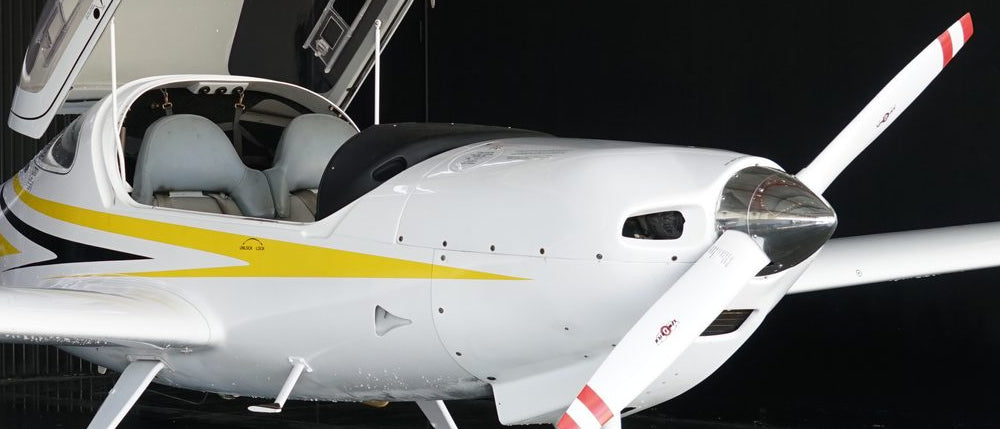 Diamond DA20 with its bubble canopy raised, showing the side-by-side cockpit