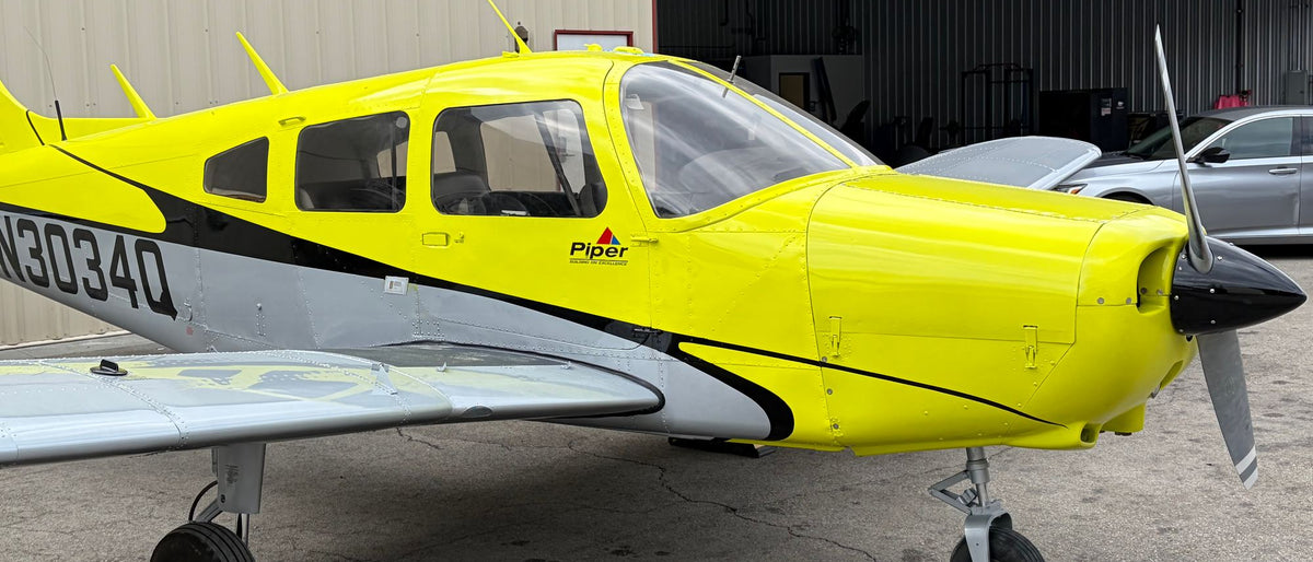 Piper Warrior N3034Q, front quarter, beside an open hangar at Van Nuys Airport