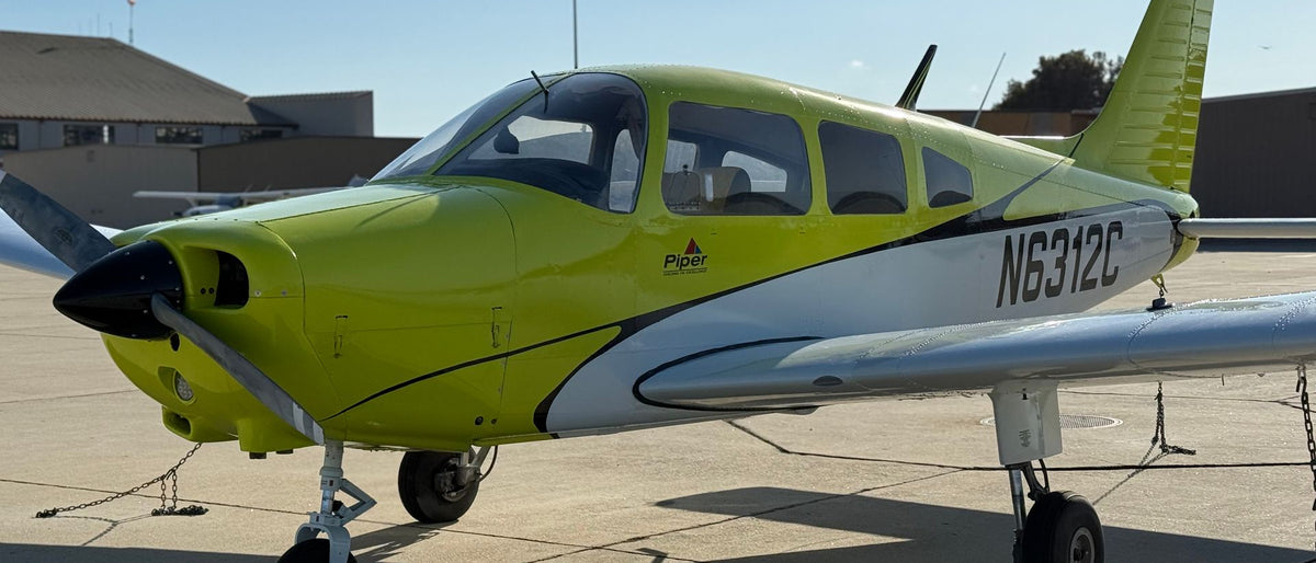 Piper Warrior N6312C, a four-seat low-wing trainer, parked on a sunny ramp