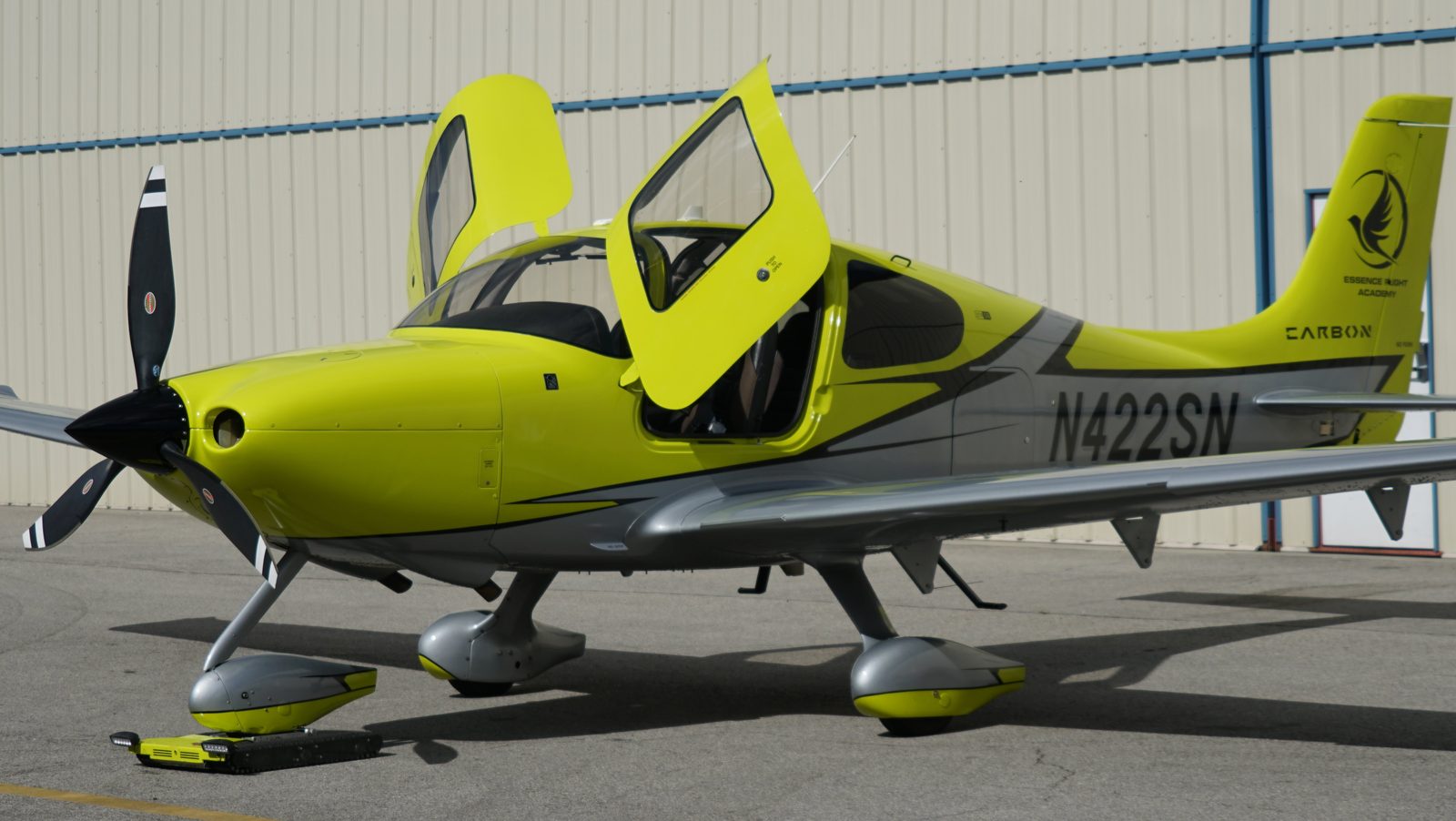 Cirrus SR22T with both doors open on the ramp outside the hangar