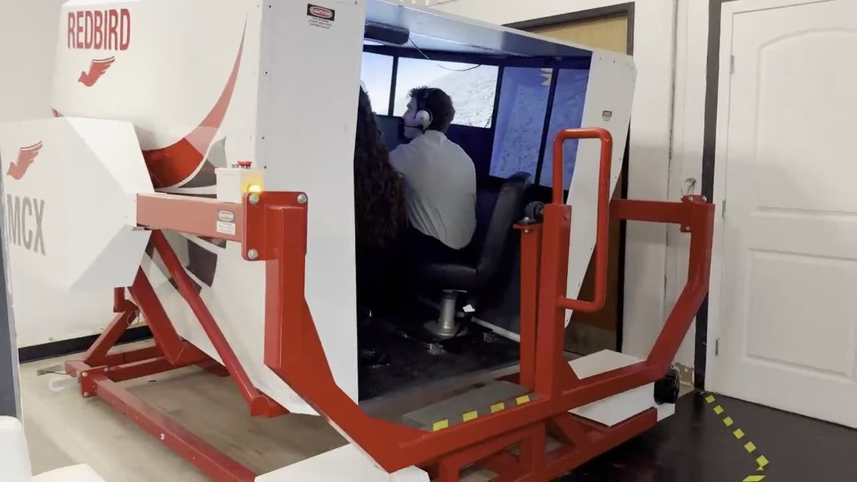 Redbird MCX full-motion flight simulator configured as a Cirrus, with a student at the controls, at You Fly LA, Van Nuys Airport