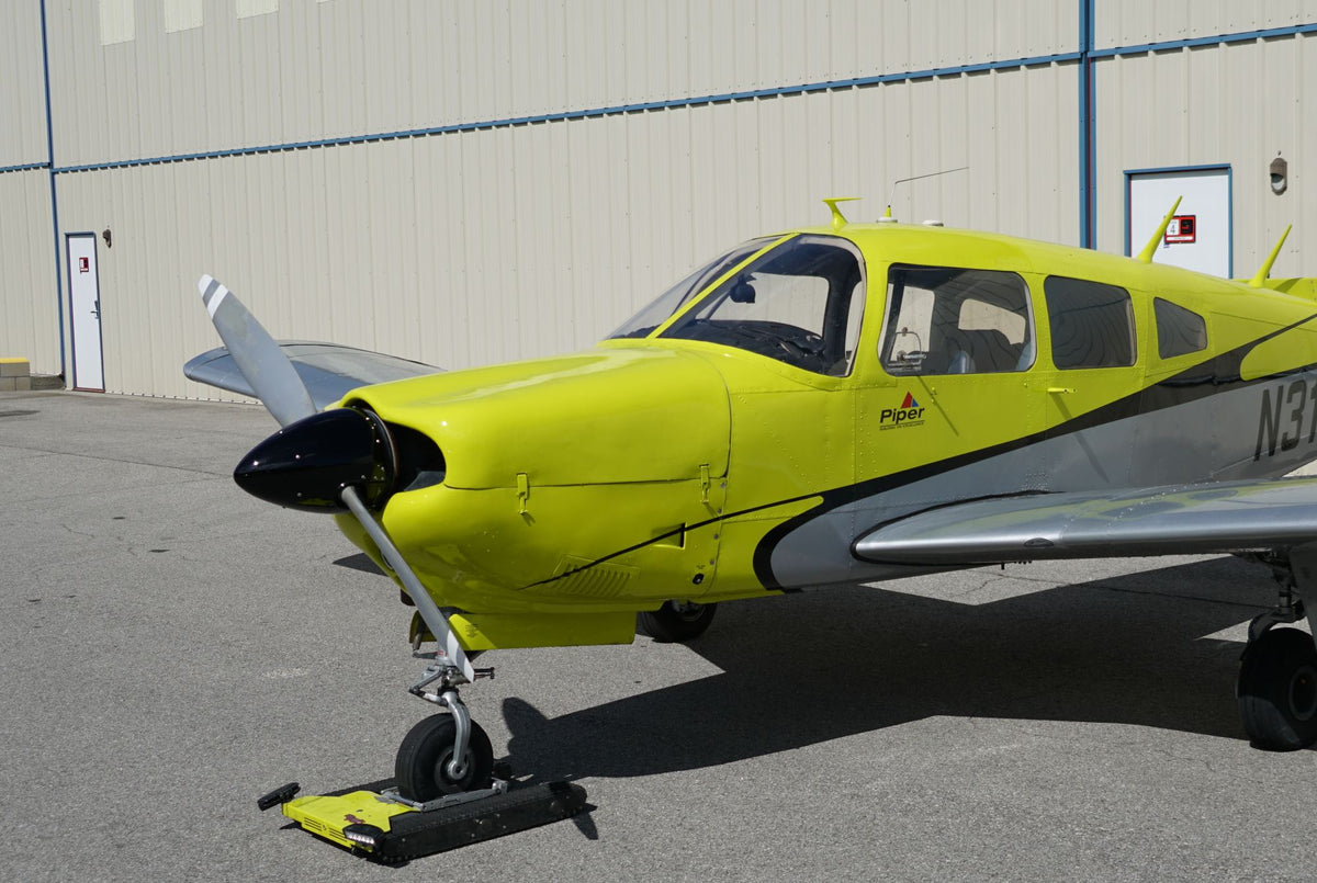 Piper Arrow N316EF, front quarter, by the hangar wall