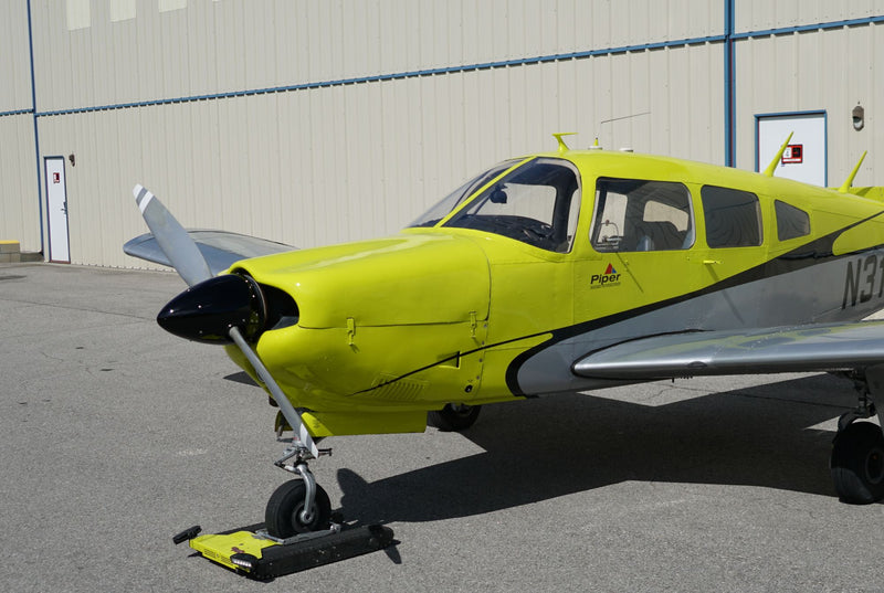 Piper Arrow N316EF, front quarter, by the hangar wall