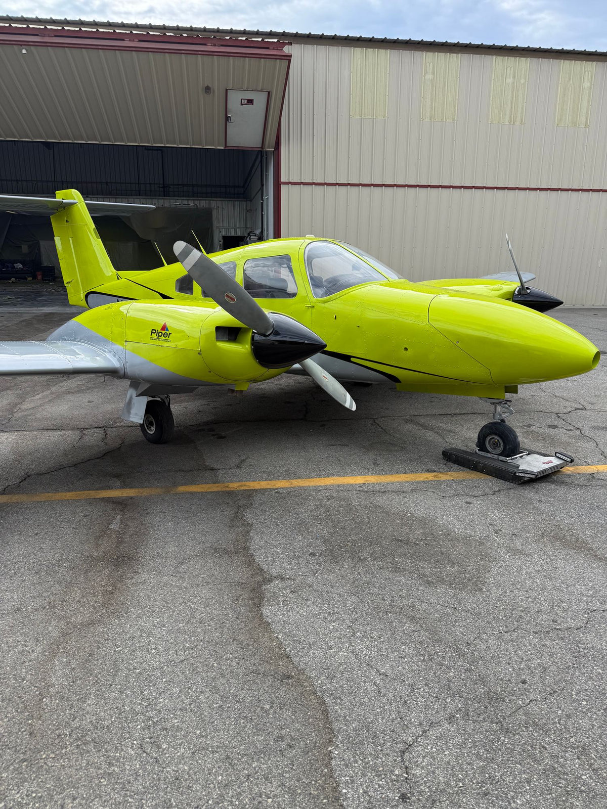 Piper Seminole in front of the open hangar