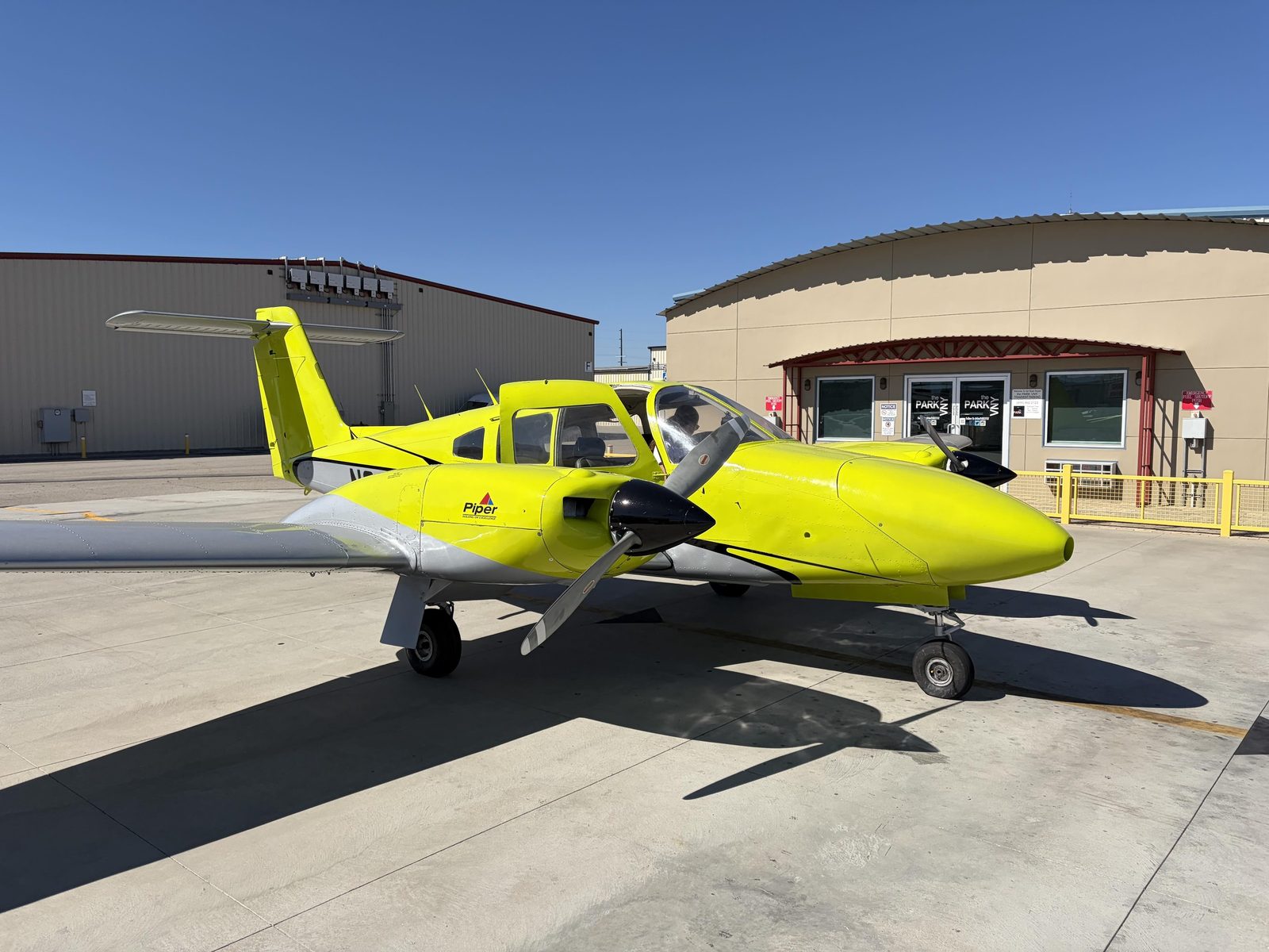 Piper Seminole parked outside the flight school office on a clear day