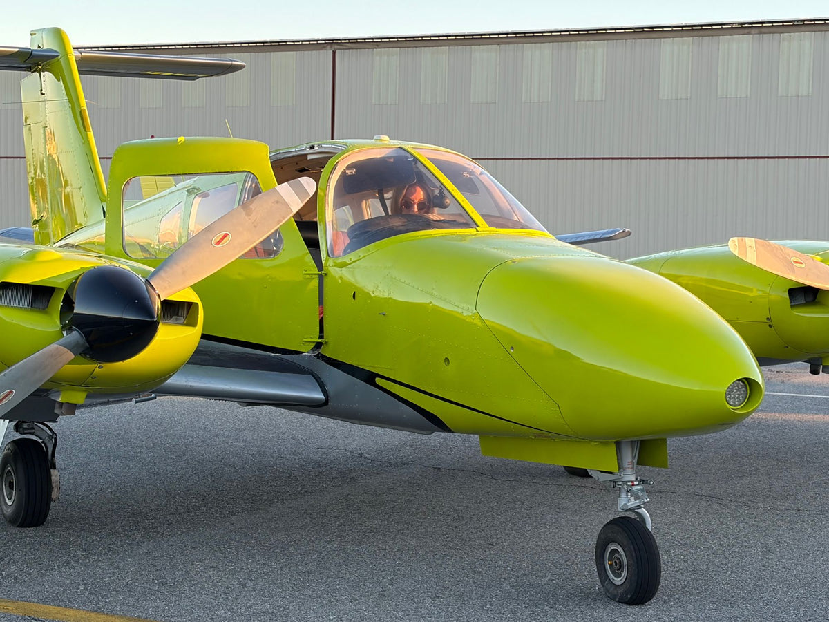 A pilot in the cockpit of the Piper Seminole at golden hour