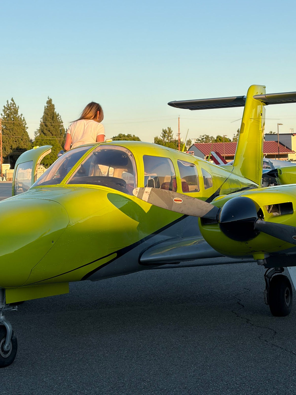Yellow Piper Seminole in low sun with a person seen from behind beside the cabin